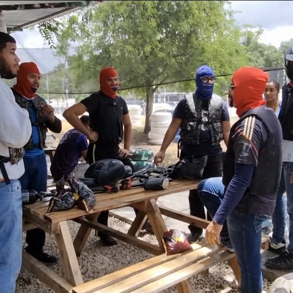 Grupo preparándose con chalecos y caretas junto a la mesa de equipos