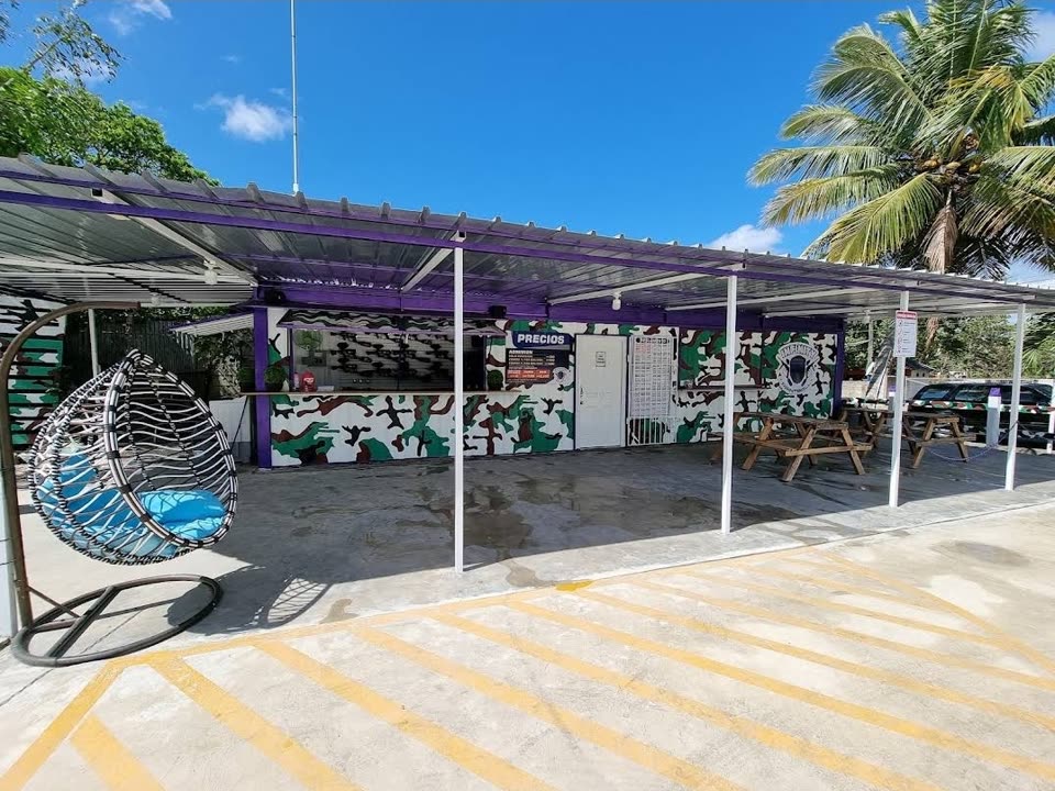 Entrada de Infinity Paintball con el mostrador, mesas y parqueo
